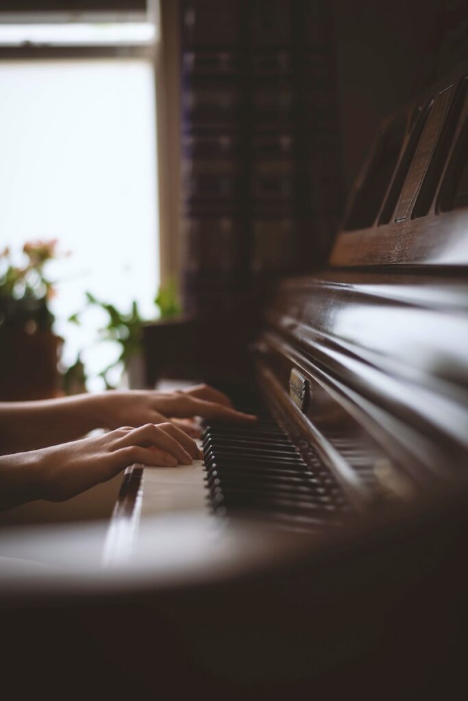 person playing piano in grayscale photography